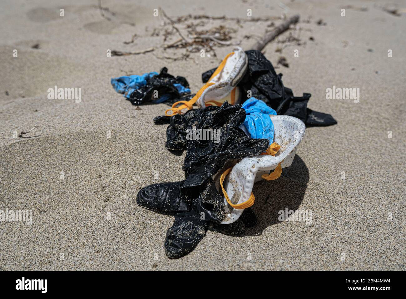 Sporco coklected maschera virus e guanti di plastica spazzatura sulla costa del mare, inquinamento covid coronavirus Foto Stock