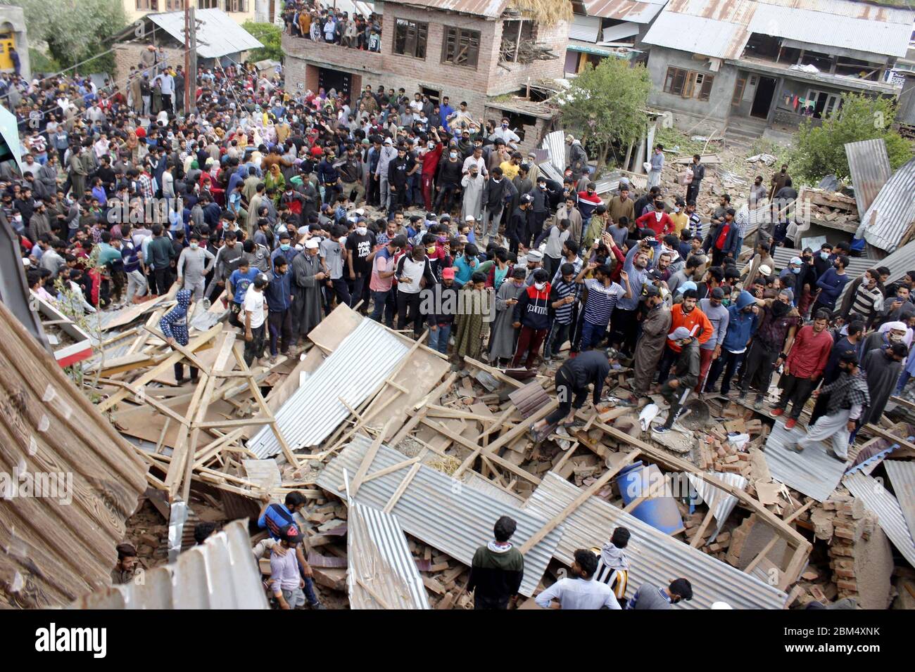 Pulwama, India. 06 maggio 2020. La gente si trova vicino ai detriti di una casa nella zona di Awantipora, a sud del Kashmir, il mercoledì. Le forze governative hanno ucciso un comandante ribelle e il suo aiuto e hanno chiuso i servizi di telefonia mobile e internet durante le proteste anti-India successive (Foto di Muneeb ul Islam / Pacific Press) Credit: Pacific Press Agency/Alamy Live News Foto Stock