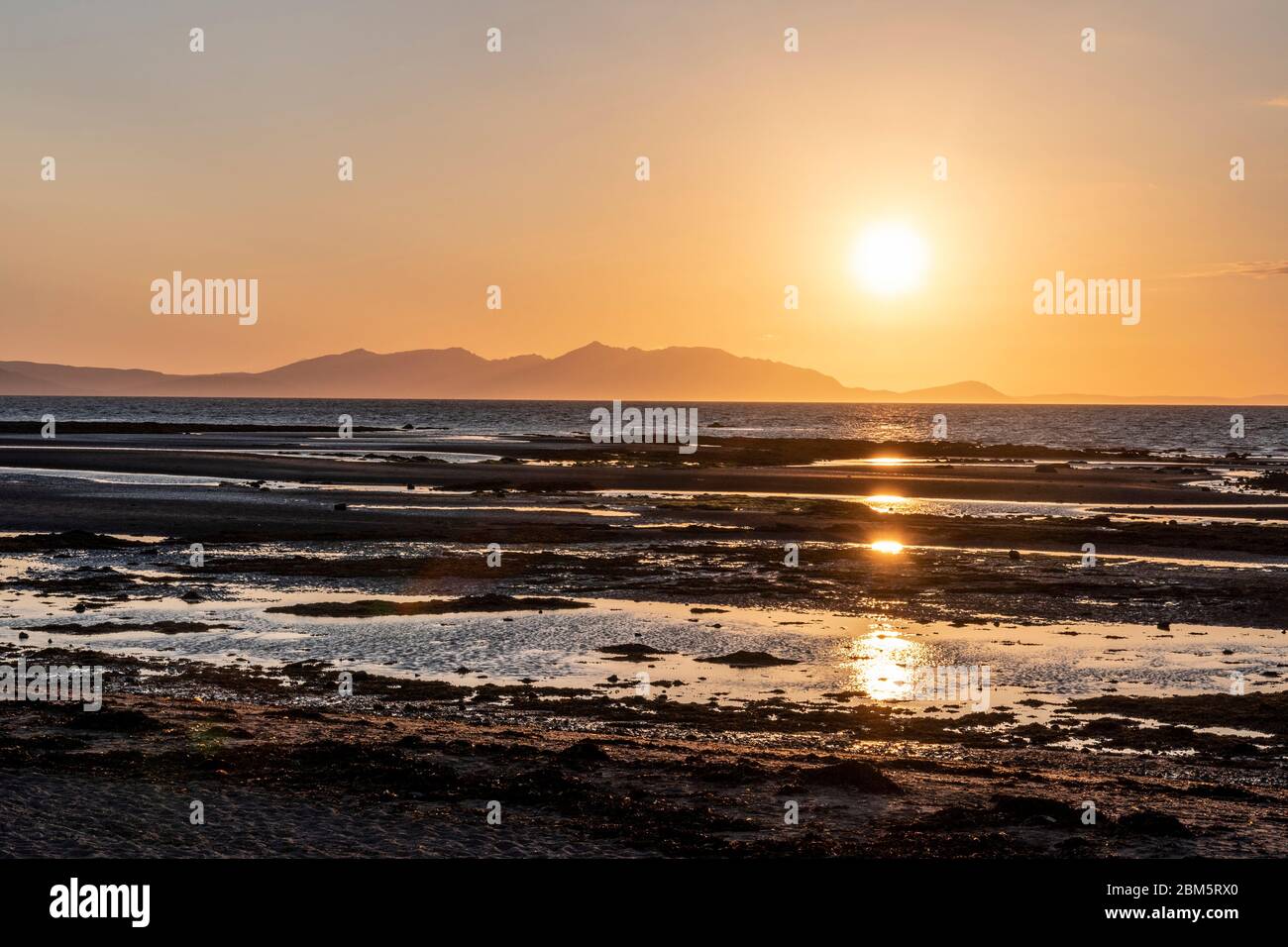 Arran tramonto dalla spiaggia al Castello di Greenan, Heads of Ayr. Foto Stock