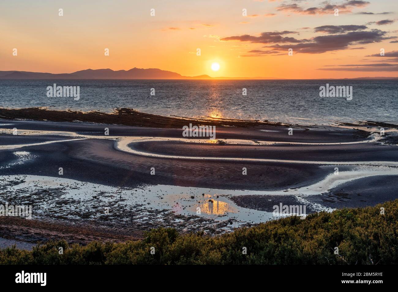 Arran tramonto dalla spiaggia al Castello di Greenan, Heads of Ayr. Foto Stock
