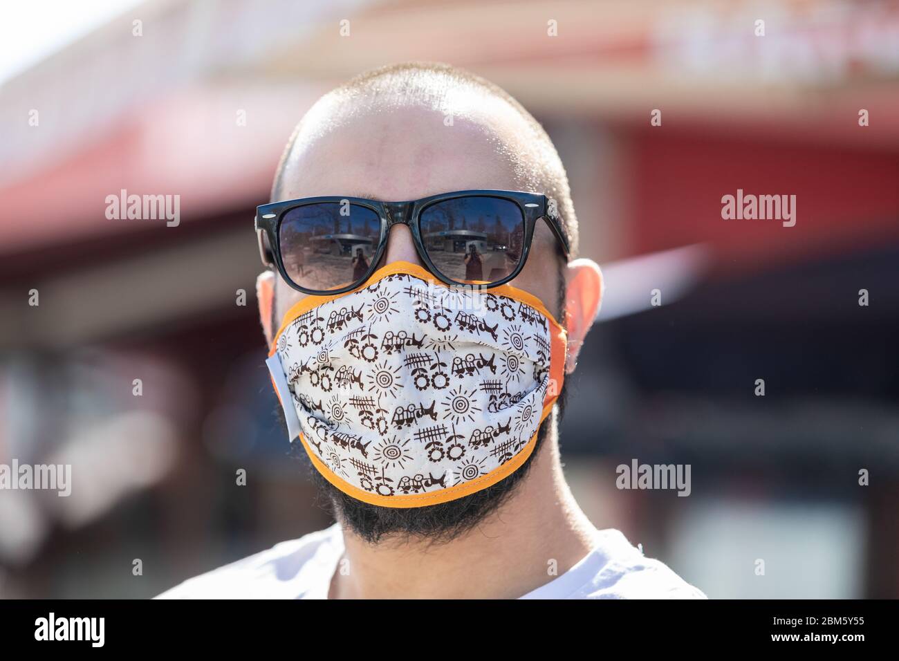 ritratto di un uomo che indossa una maschera protettiva colorata e divertente Foto Stock