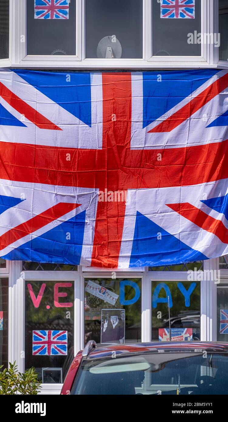 Morden, Surrey, Regno Unito. 7 maggio 2020. Union flag copre la facciata di una casa nel sud-ovest di Londra Borough di Merton per celebrare il 75 ° anniversario del VE Day, anche con foto di Churchill dare il suo V per il segno della vittoria. Credit: Malcolm Park/Alamy Live News. Foto Stock