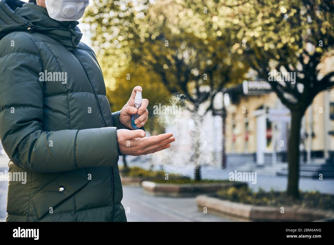 Un'istantanea ravvicinata delle mani della donna, per strada, pulendole le mani con spray lavasmani come misura igienica preventiva contro le infezioni. Misure preventive durante il regime di quarantena Foto Stock
