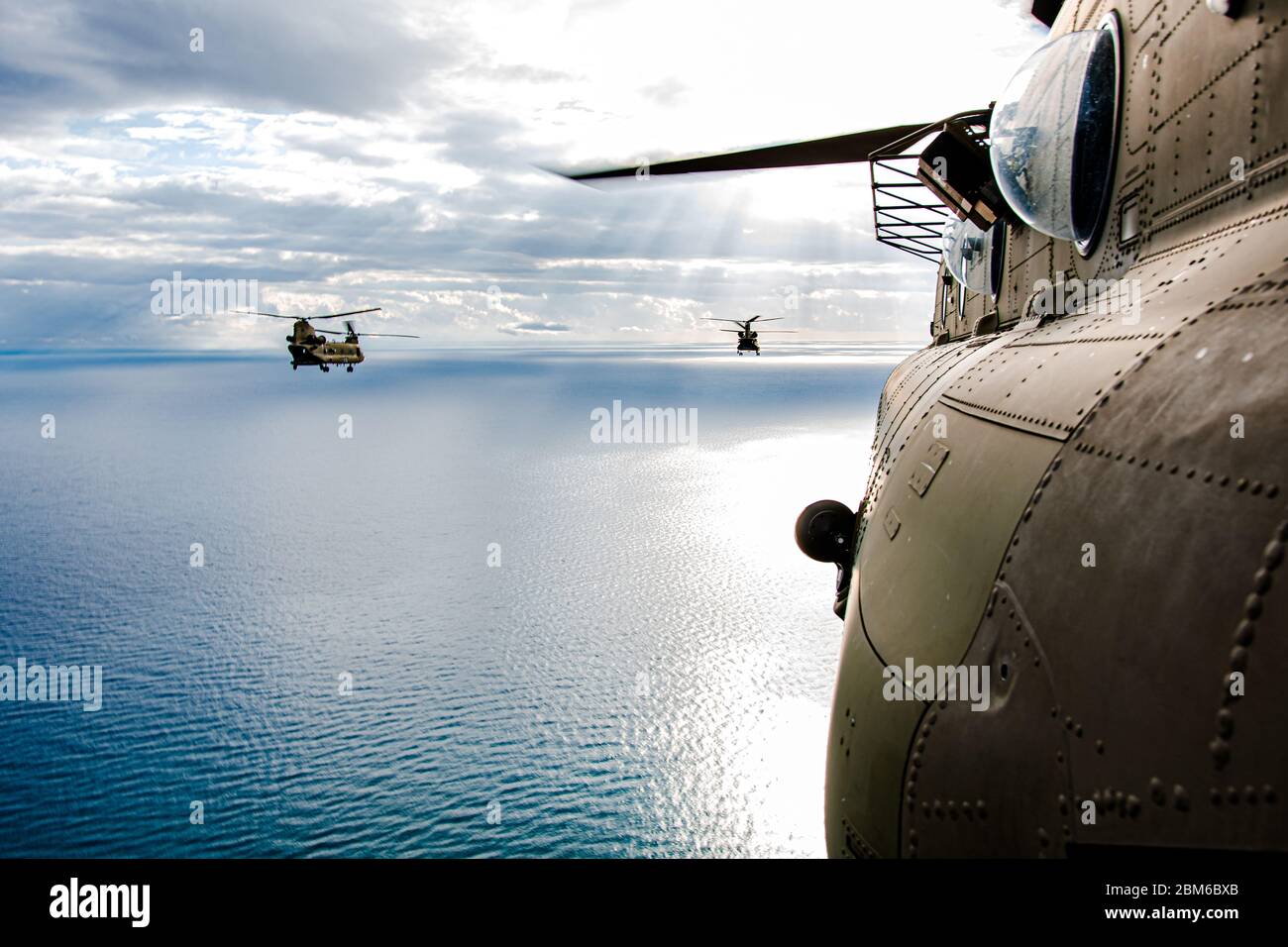 Una formazione di CH-47 's che conduce l'addestramento sopra-acqua vicino Cipro. La dodicesima brigata dell'aviazione di combattimento e i paracadutisti della 173esima squadra di combattimento della brigata di fanteria Airborne lavorano a mano per costruire la preparazione durante l'esercizio. Foto Stock