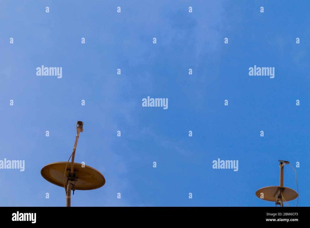 Due antenne satellitari con spazio su cielo blu. Sfondo. Foto Stock