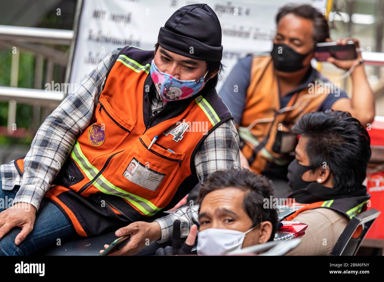 Motociclista con maschera facciale in attesa di clienti durante Covid 19 pandemic, Bangkok, Thailandia Foto Stock