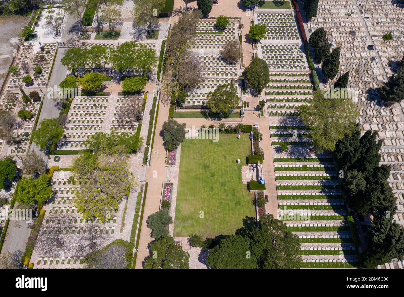 Cimitero militare al Memorial Day con bandiera sventolante e ufficiali dell'esercito in uniforme bianca, vista aerea. Foto Stock