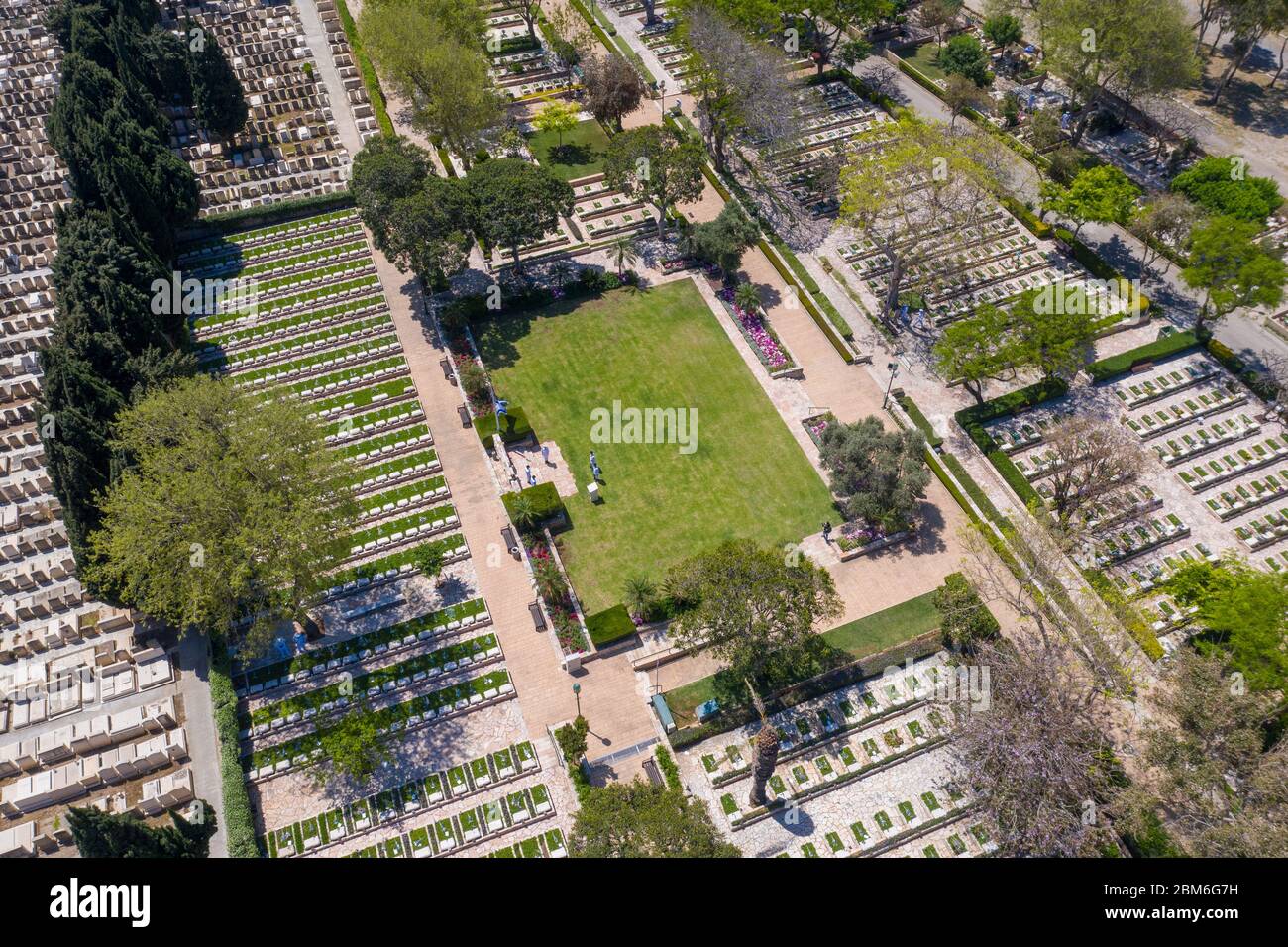 Cimitero militare al Memorial Day con bandiera sventolante e ufficiali dell'esercito in uniforme bianca, vista aerea. Foto Stock