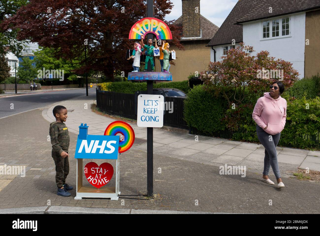 Con la promessa di un'installazione di Corinavirus nel Regno Unito che si rilassa entro un paio di giorni, l'artista locale di Belle Arti Kevin McKeon ha aggiunto alla sua opera d'arte esistente con un altro tributo e grazie ai lavoratori NHS (National Health) che passano da questa posizione a Herne Hill nel sud di Londra, Il 7 maggio 2020, a Londra, Inghilterra. Oltre alla sua già popolare 'casa' NHS sul marciapiede, McKeon (la cui pratica artistica è normalmente figurativa e progetti di scultura del patrimonio) ha creato un podio circolare attaccato ad un palo di segnaletica stradale, di dipendenti in miniatura della sanità in possesso di cartelli lettura 'Salva Foto Stock