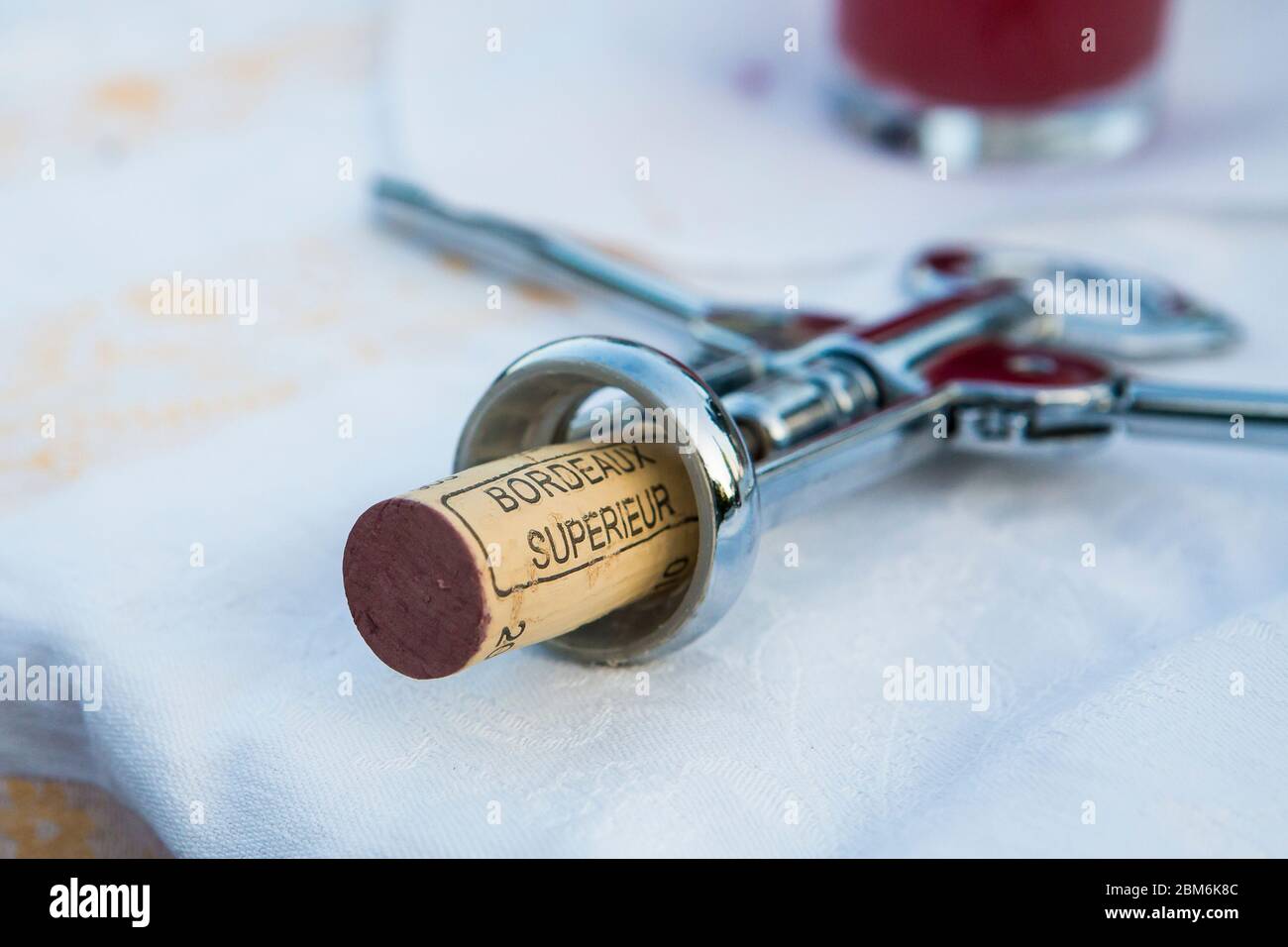 Tappo in sughero naturale in cavatappi alato dall'apertura di una bottiglia di vino rosso Bordeaux superiore francese in un picnic all'aperto nel Kent, Regno Unito Foto Stock