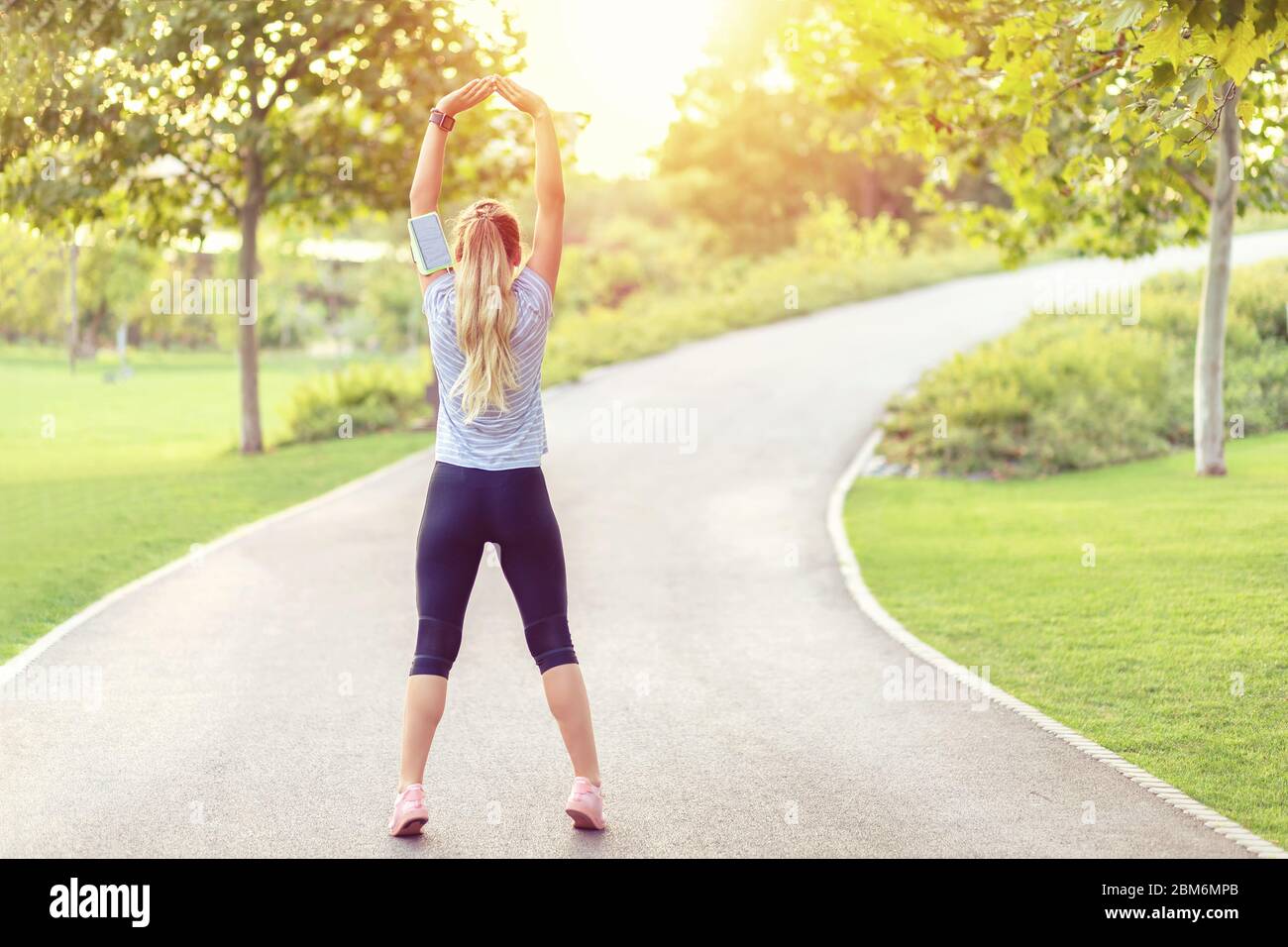 Vista posteriore della donna jogging in parco vuoto a causa di misure di distanza sociale Foto Stock