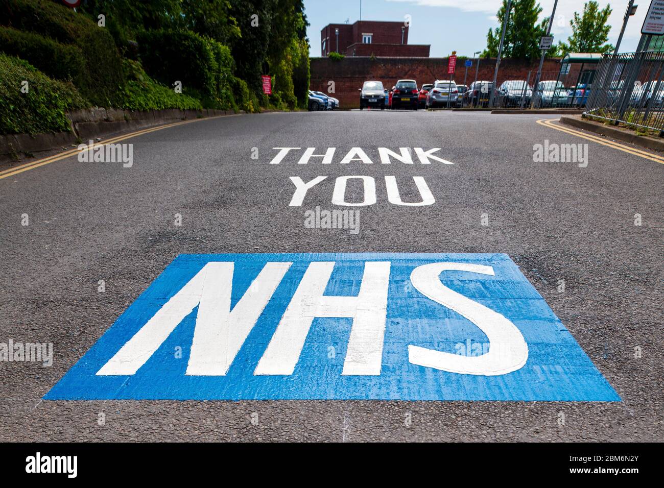 Grazie NHS vernice stradale dipinto Regno Unito. Messaggio di supporto i nostri caregivers all'ingresso di un parcheggio vicino all'ospedale, Inghilterra. Foto Stock