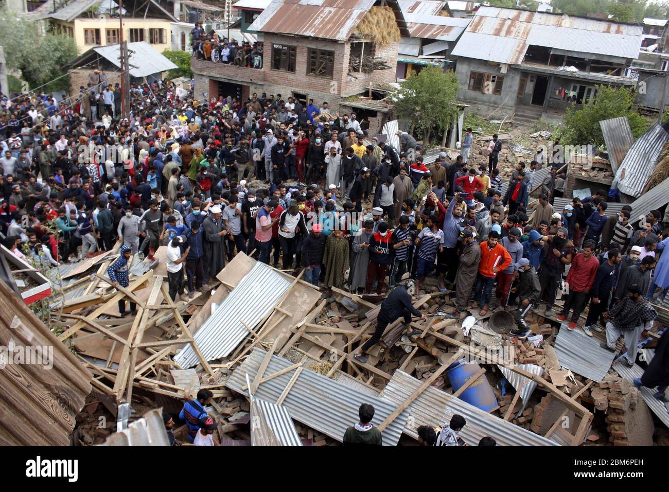 Pulwama, India. 06 maggio 2020. La gente si trova vicino ai detriti di una casa nella zona di Awantipora, a sud del Kashmir, India, mercoledì 6 maggio 2020. Le forze governative hanno ucciso un comandante ribelle e il suo aiuto e hanno chiuso i servizi di telefonia cellulare e internet mobile durante le successive proteste anti-India (Foto di Muneeb ul Islam/ Pacific Press/Sipa USA) Credit: Sipa USA/Alamy Live News Foto Stock