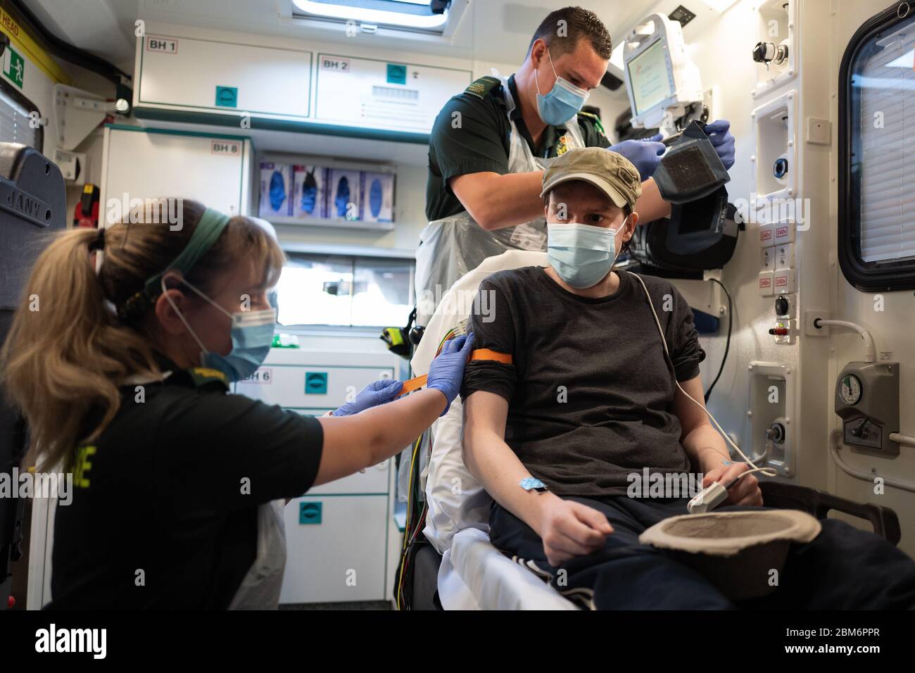 NOTA PER I REDATTORI: Il paziente ha dato il consenso per essere fotografato. Il paramedico Nikki Philpott (a sinistra) e il paramedico James Hansford curano un paziente in cabina di un'ambulanza che ha precedentemente testato positivo per Covid-19 a Portsmouth, Hampshire. Foto Stock