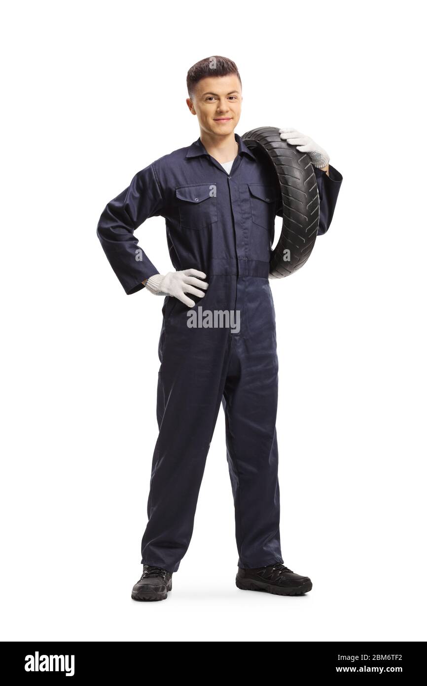 Ritratto a tutta lunghezza di un meccanico che trasporta un pneumatico della moto e sorride alla macchina fotografica isolata su sfondo bianco Foto Stock