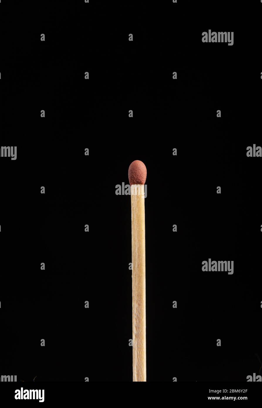 Un singolo fiammiferi non illuminato su sfondo nero Foto Stock