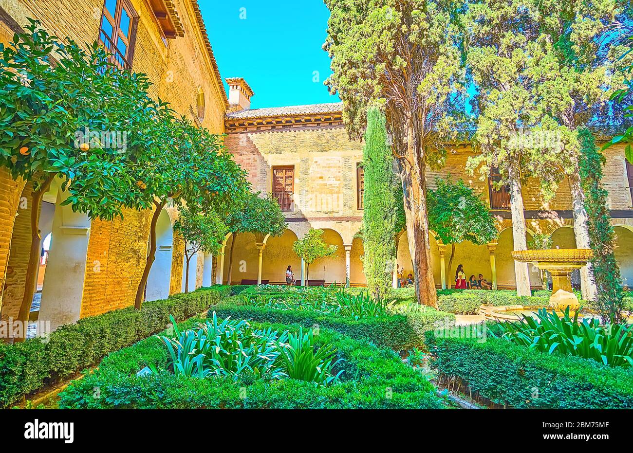 GRANADA, SPAGNA - 25 SETTEMBRE 2019: Passeggiata nel giardino ornamentale di Daraxa del Palazzo Nasrid in Alhambra e godere degli alberi di arancio, cespugli topiari e v Foto Stock