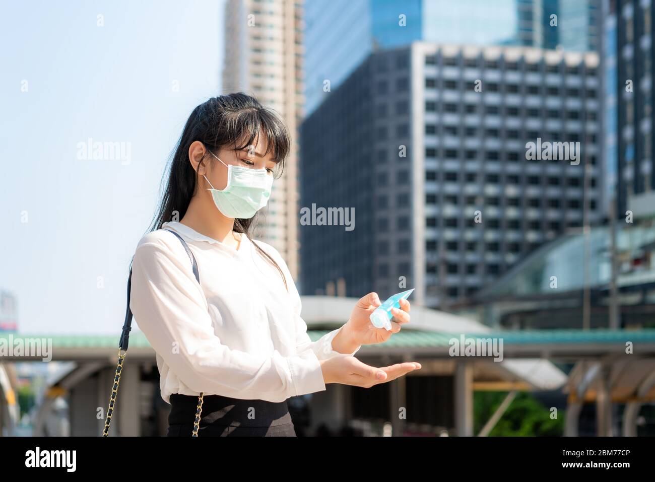 Donna d'affari asiatica che usa il dispenser di gel igienizzante per mani di lavaggio mentre Coronavirus Network focolaio, assistenza sanitaria e pulizia per prevenire covid19 conceptina Foto Stock