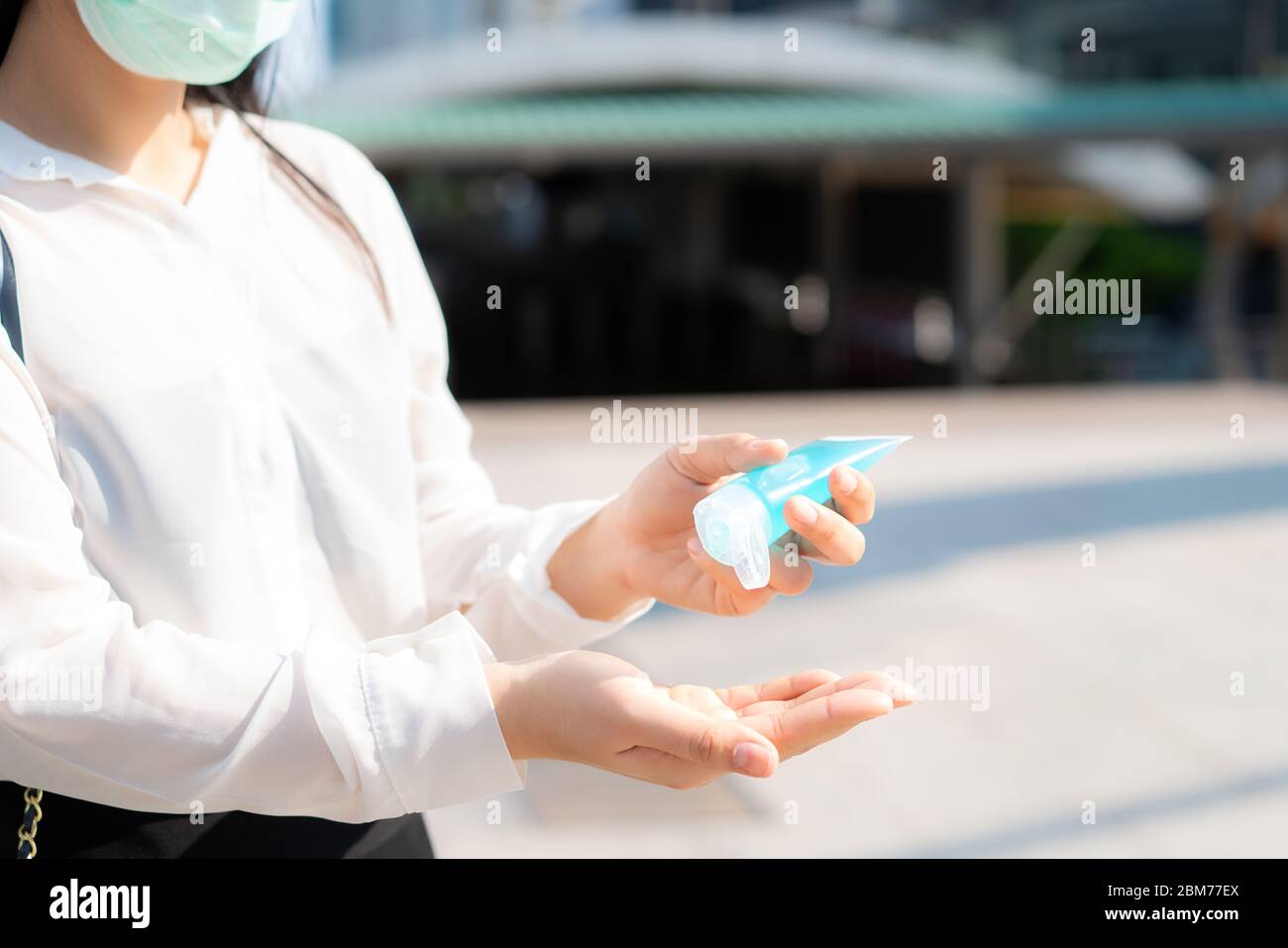 Donna d'affari asiatica che usa il dispenser di gel igienizzante per mani di lavaggio mentre Coronavirus Network focolaio, assistenza sanitaria e pulizia per prevenire covid19 conceptina Foto Stock