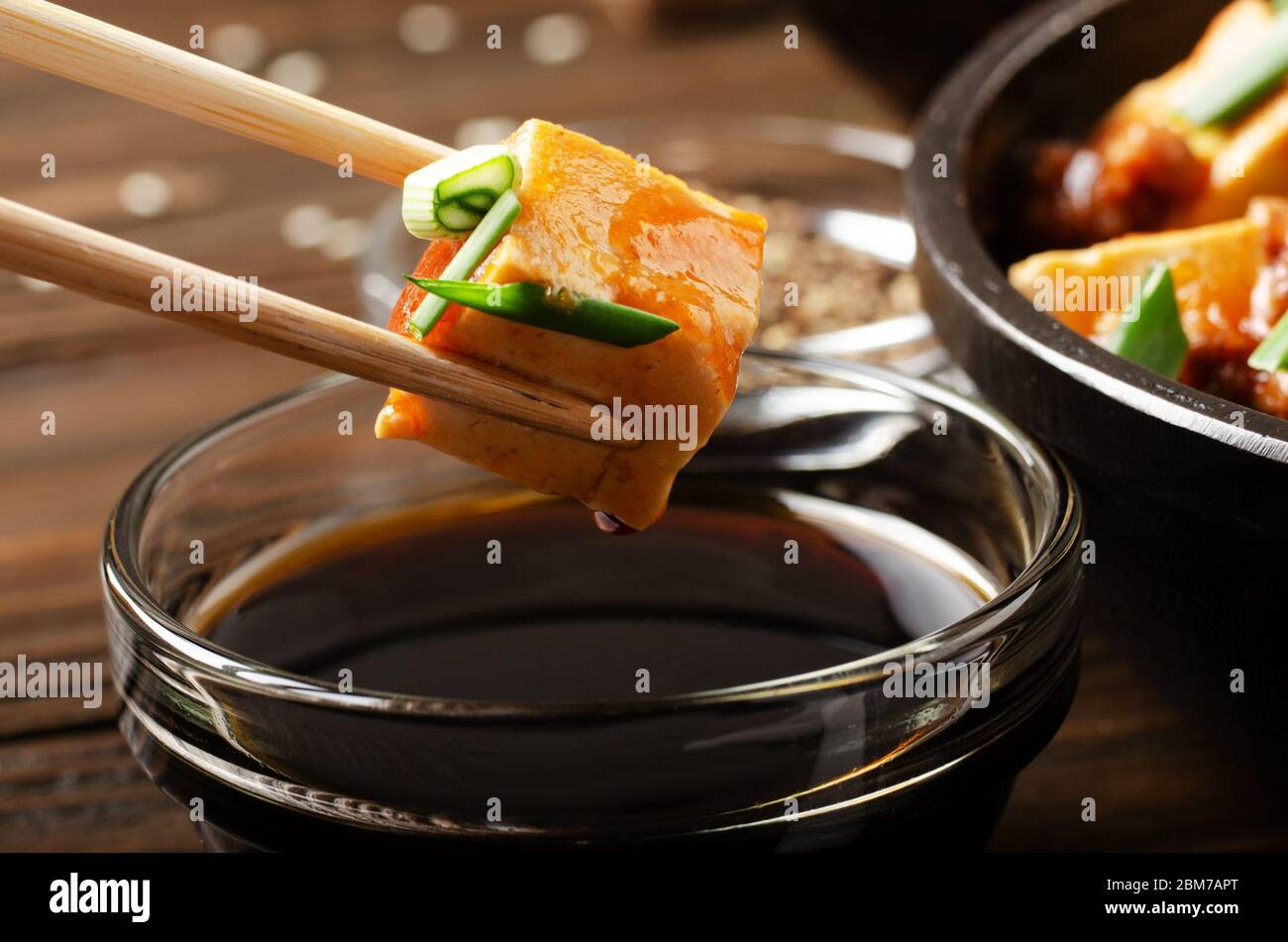 Piatto di tofu di Mapo di cagliata di soia che è tenuto in bacchette Foto Stock