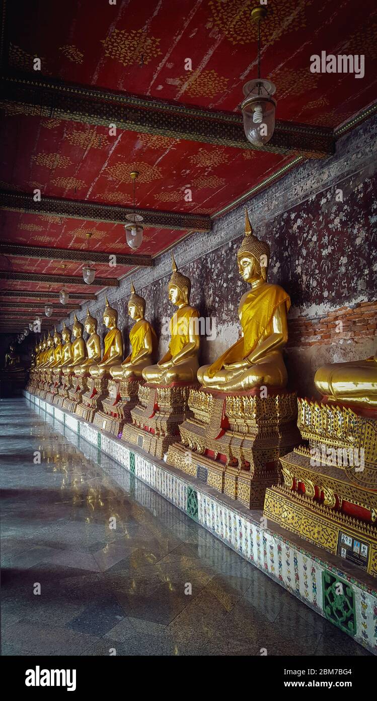 Golden meditating statue di Buddha d'oro che si trovano in una fila in UN corridoio in Wat Suthat Thepwararam Tempio Bankok, Thailandia 25/11/2019 Foto Stock