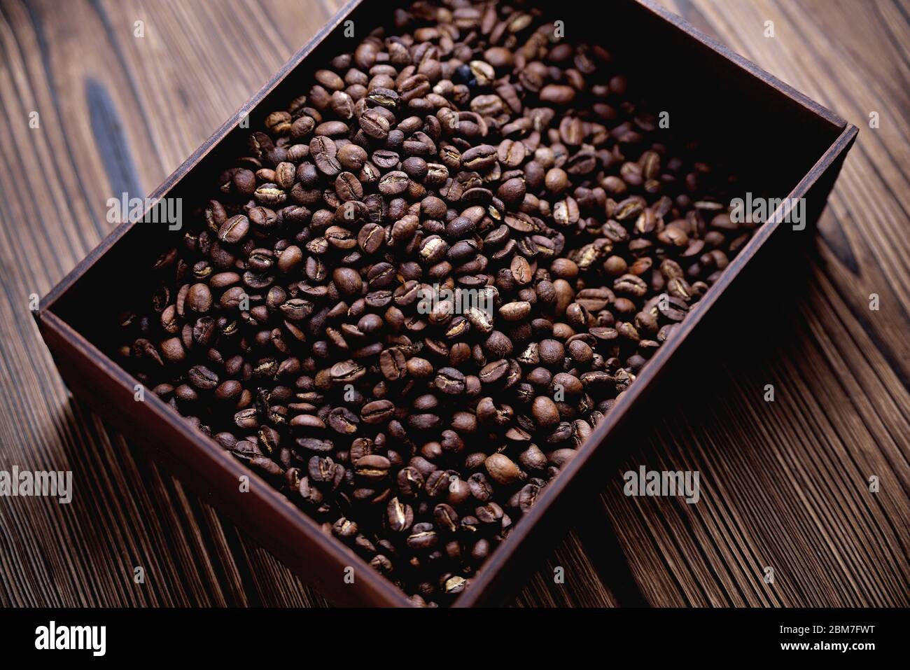 caffè naturale in chicchi di legno in una scatola di legno su uno sfondo  naturale di legno chiaro e morbido retroilluminazione Foto stock - Alamy