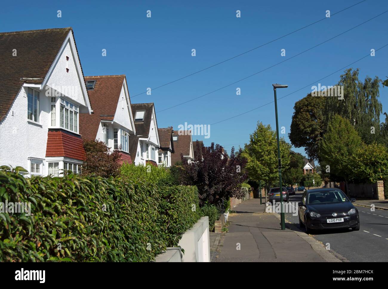 case indipendenti con finestre a bovindo a teddington, middlesex, inghilterra, situato dietro siepi privati su una strada alberata. Foto Stock