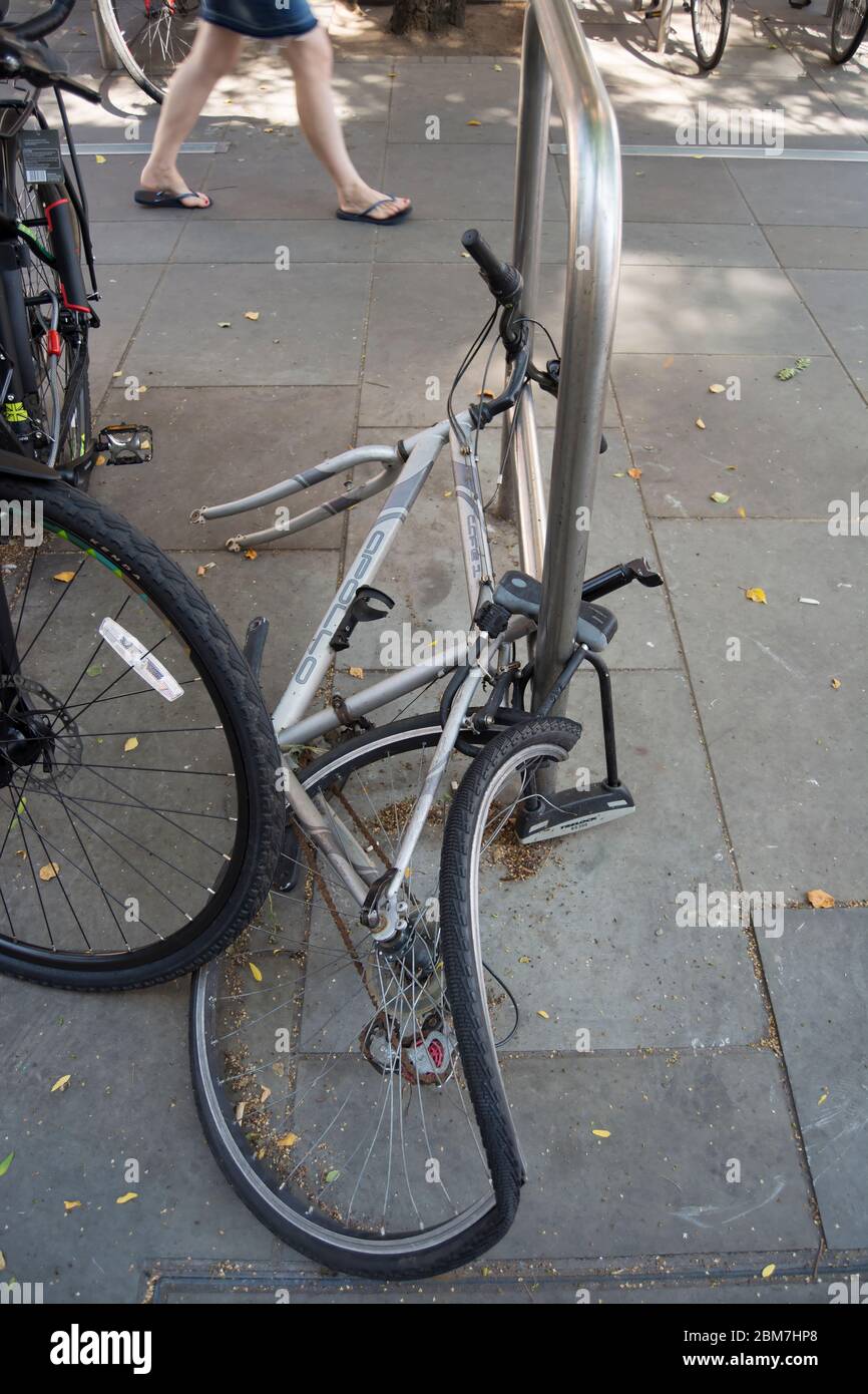 bicicletta parcheggiata e bloccata con ruota anteriore mancante e ruota posteriore rotta, probabilmente a causa di un tentativo di furto, a richmond, surrey, inghilterra Foto Stock