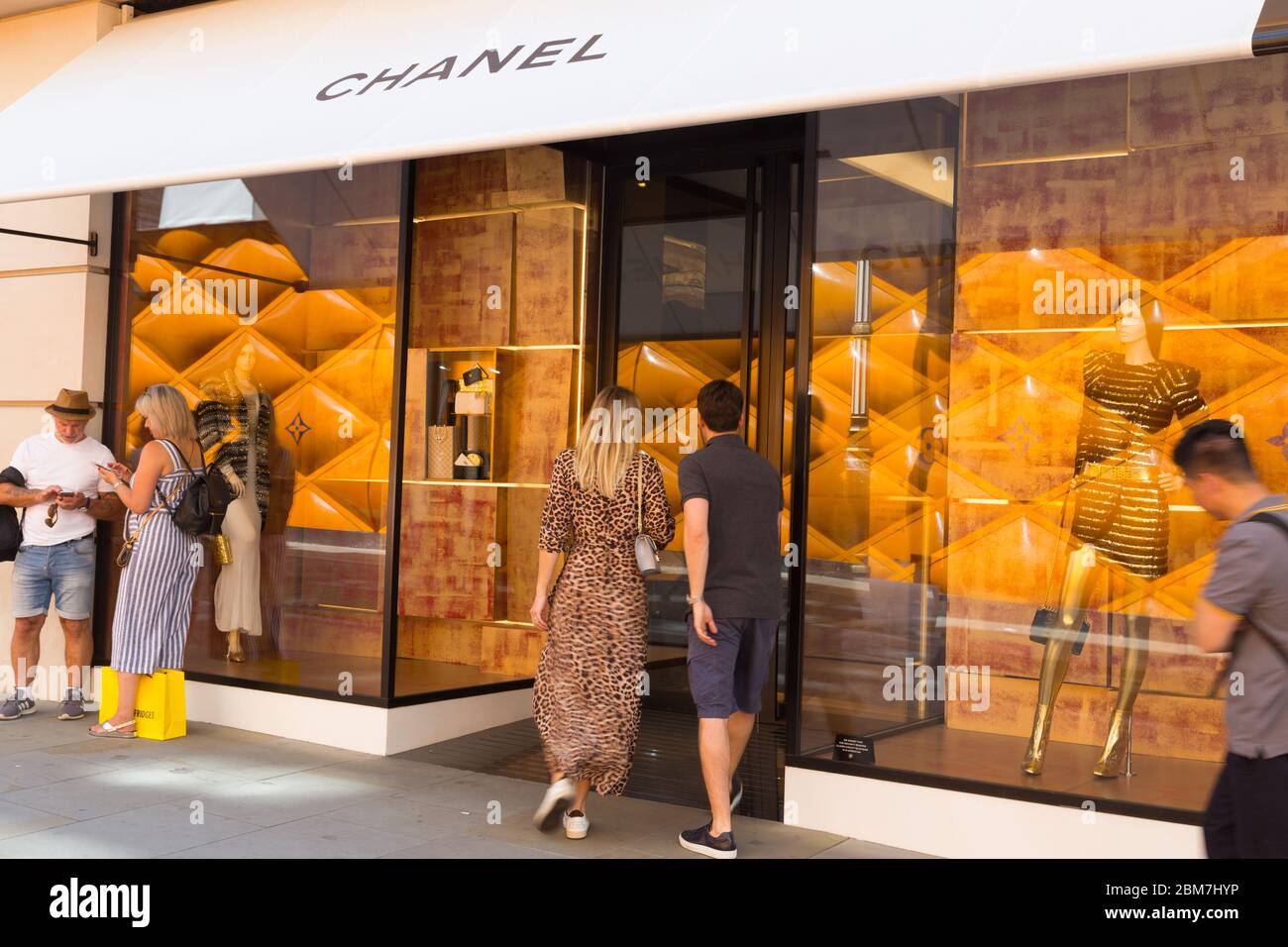 Gli amanti dello shopping estivo che vogliono andare oltre il lussuoso negozio di marchi Chanel su Bond Street, nel West End di Londra Foto Stock