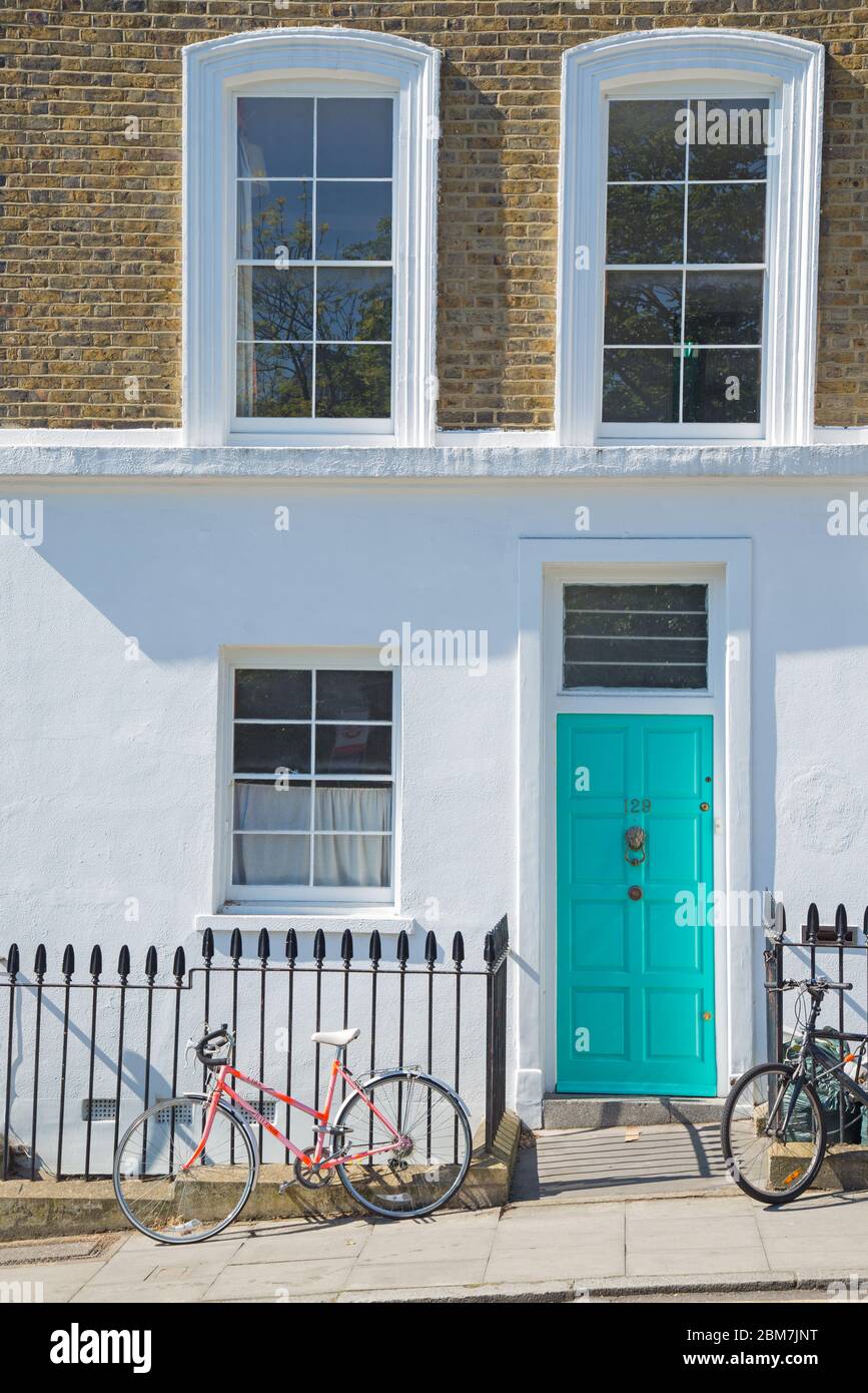 biciclette chiuse a ringhiere all'esterno di una casa cittadina ben tenuta a Islington, a nord di Londra Foto Stock