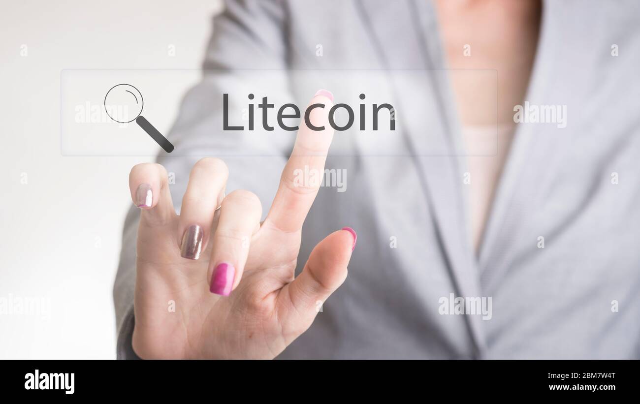 Persona di lavoro femminile non identificabile che batte il testo della litecoin su monitor trasparente per il concetto circa il banking moderno e la tecnologia informatica. Foto Stock