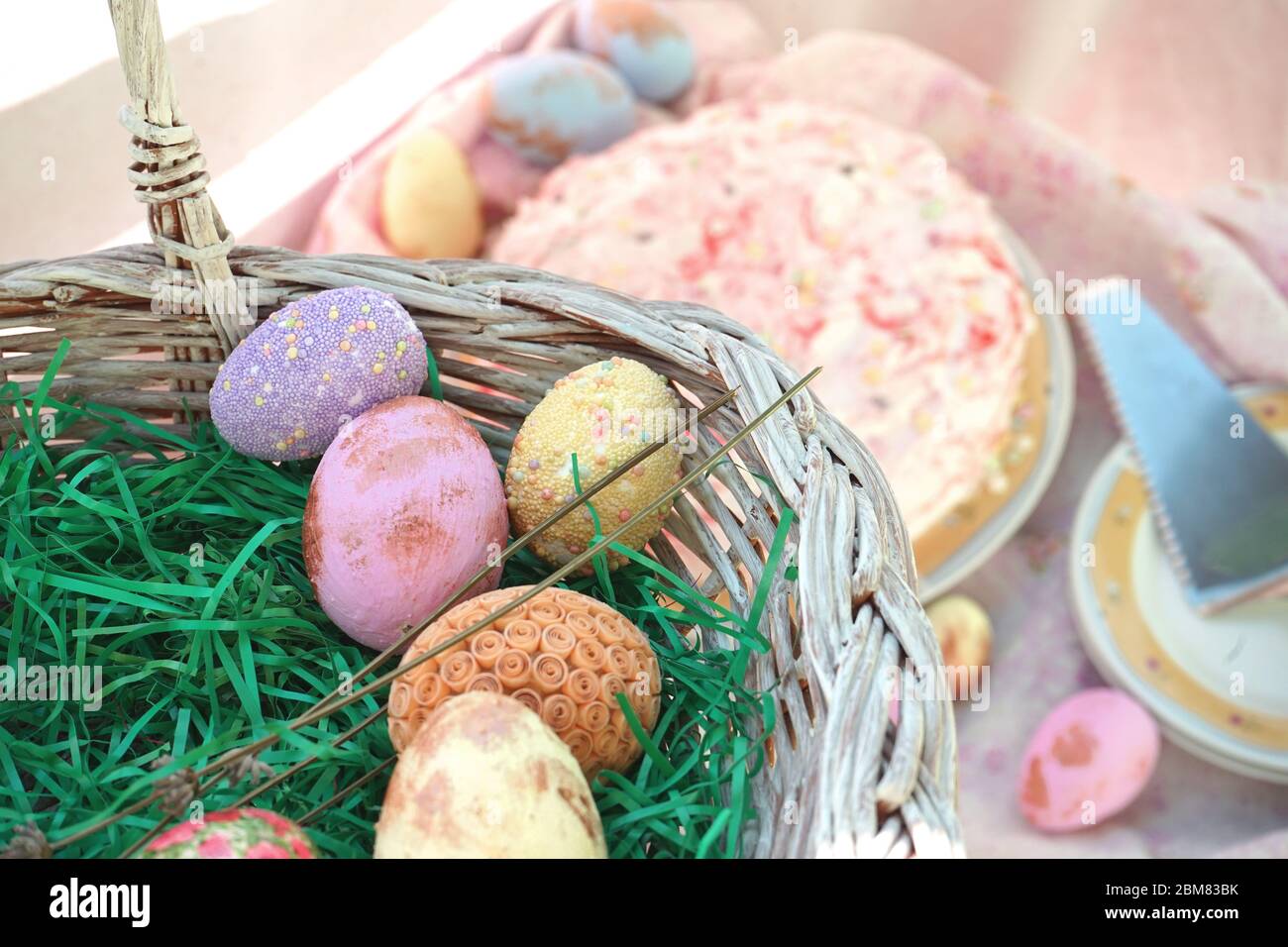 Cestino di Pasqua pieno di uova. Torta di fragole. Decorazione dell'acqua. Foto Stock