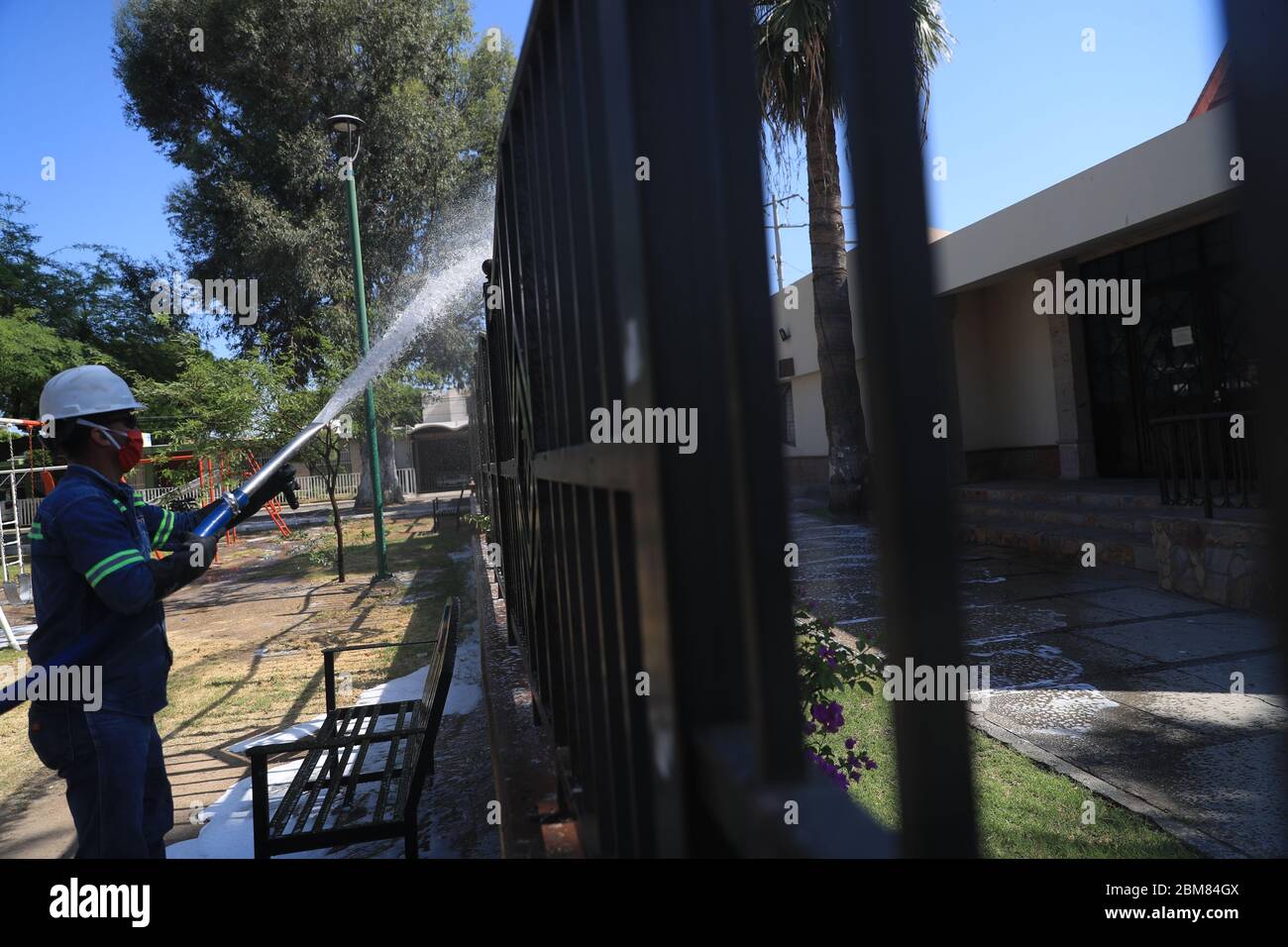 I lavoratori del consiglio comunale svolgono lavori di sanificazione a causa della pandemia di Covid 19, utilizzando liquidi pressurizzati per pulire la piazza pubblica di Niños Héroes. Giocano giochi per bambini, alberi, una statua e monumenti per gli eredi dell'indipendenza del Messico: Juan de la Barrera, Juan Escutia, Agustín Melgar, Fernando Montes de Oca, Vicente Suárez e Francisco Márquez. Hermosillo, sonora al 7 maggio 2020. (Foto: Luis Gutierrez / NortePhoto.com) Trabajadores del ayuntamiento realizan trabajos de sanitización de vido a la pandemia del Covid 19 usando líquidos a pressionion para limpiar la plaza pubica ni Foto Stock