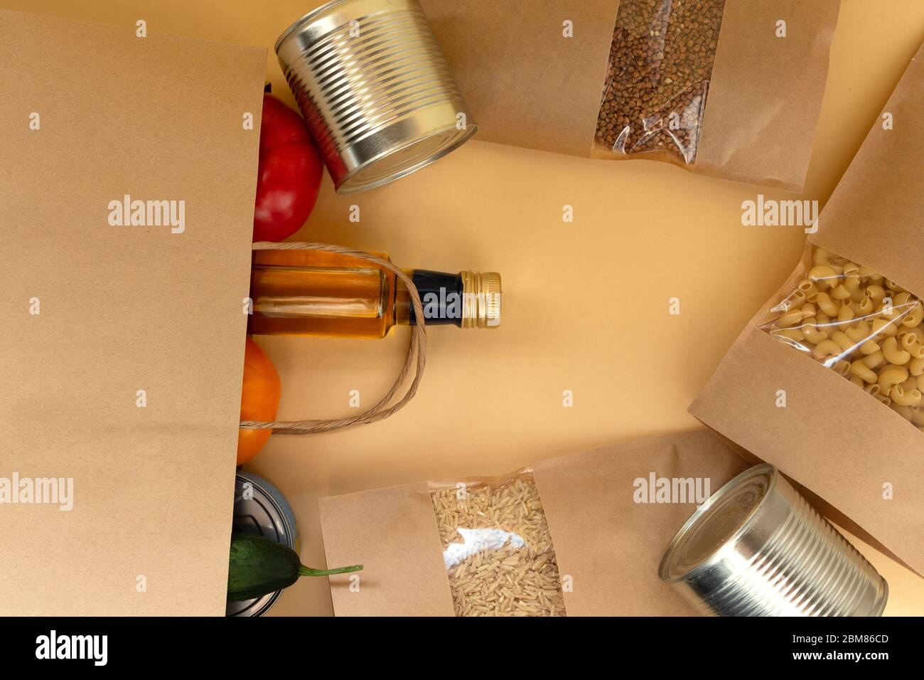 Un insieme di rifornimenti alimentari necessari. Grano saraceno, pasta, riso in un doypack kraft, cibo in scatola, olio, verdure. Consegna di cibo. Donazione Covid Foto Stock