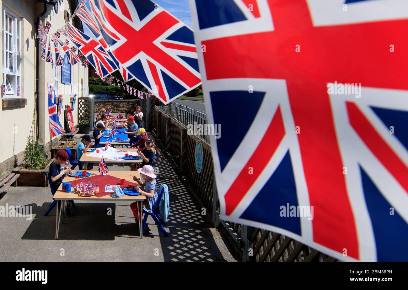 Bambini e personale della Breadsall Primary School di Derby durante una festa pranzo del VE Day per celebrare il 75° anniversario della fine della seconda guerra mondiale in Europa. Foto Stock