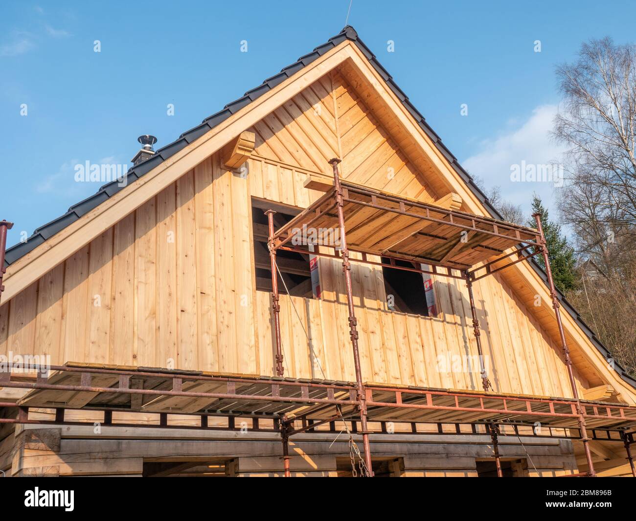 Casa di famiglia in legno in costruzione, casa di costruzione con impalcatura pieghevole Foto Stock