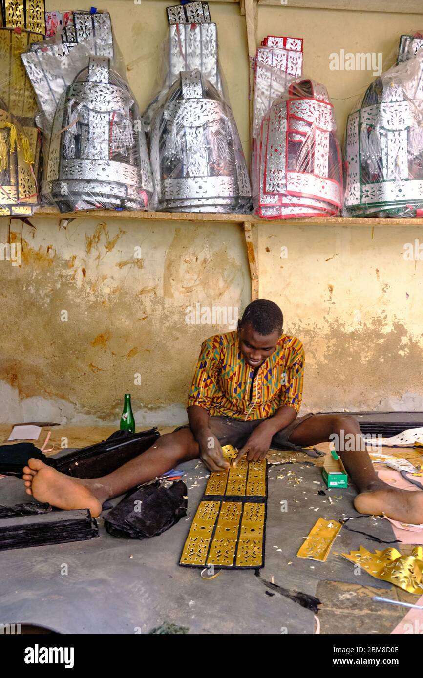 Artigiano che fa decorazioni per decorare i cavalli in vacanza, in una piccola bottega nel mercato di Kano. Foto Stock