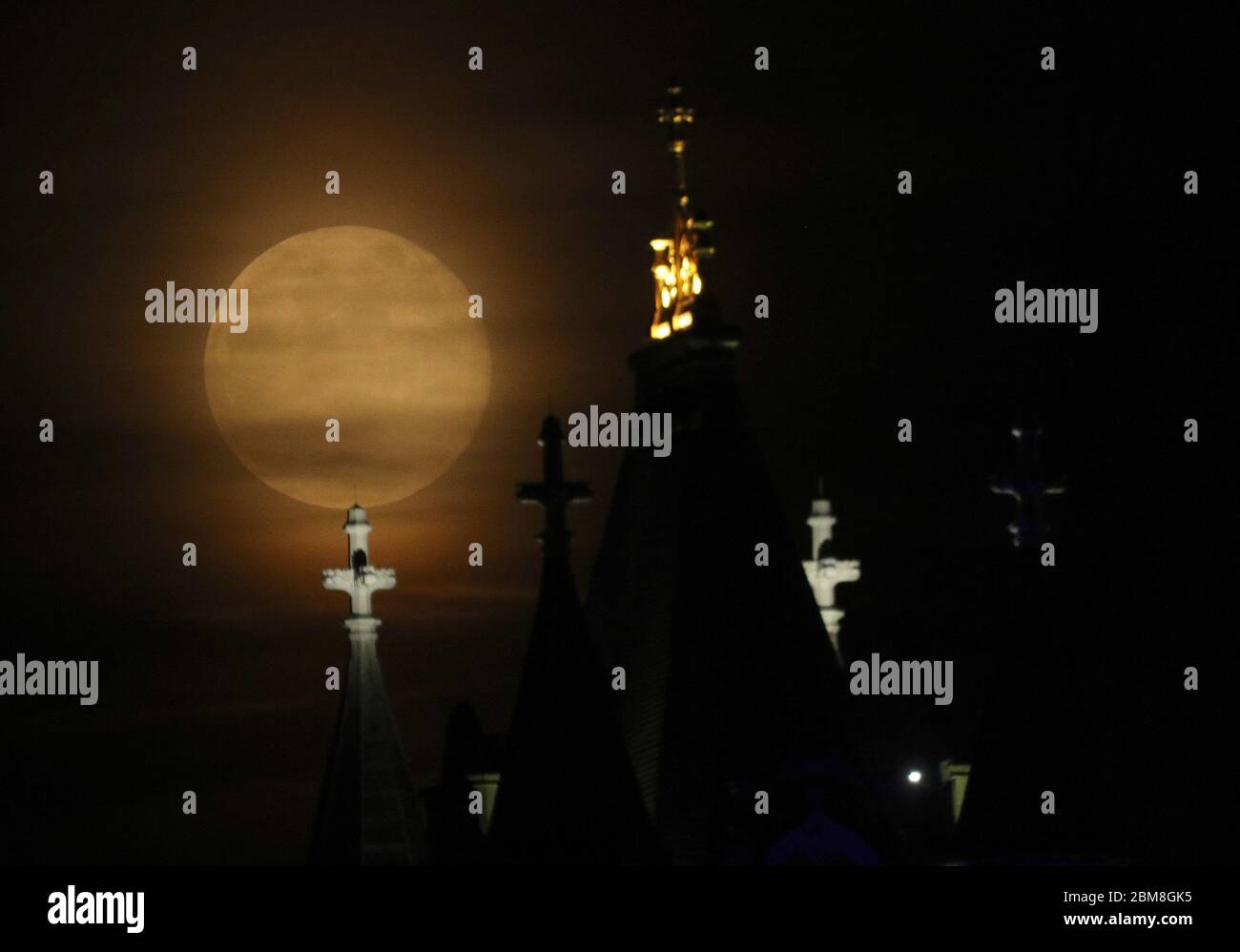 La luna sorge sul Tower Bridge di Londra, illuminato in blu a sostegno dell'NHS, per l'ultima superluna dell'anno. La luna piena di maggio è anche conosciuta come la "luna di fiori", che significa i fiori che fioriscono durante il mese. Data foto: Giovedì 7 maggio 2020. La superluna di questo mese è circa il 6% più grande di una tipica luna piena e circa il 14% più grande di una micromouna, che è quando la luna è al suo punto più lontano dalla Terra. Vedi la storia della PA SCIENCE Supermoon. Il credito per le foto dovrebbe leggere: Yui Mok/PA Wire Foto Stock