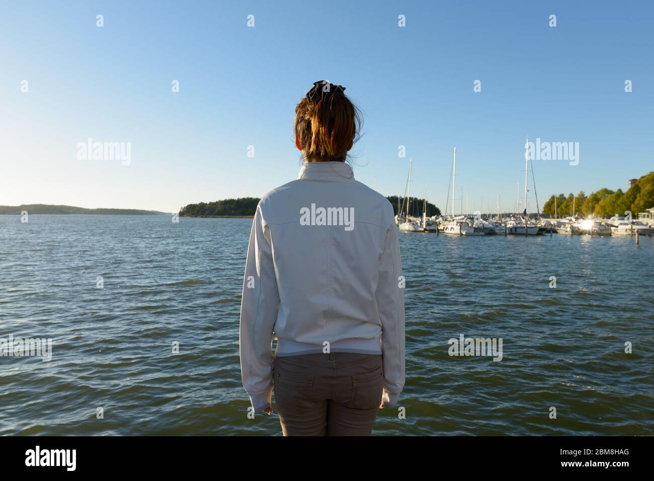 Vista posteriore della giovane donna asiatica che guarda il mare Foto Stock