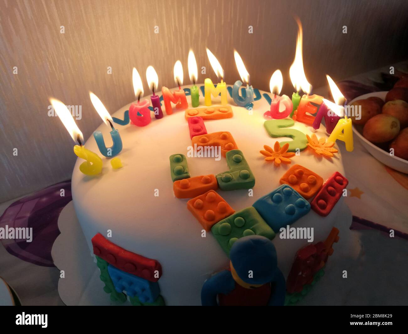 Dolce torta di compleanno di 5 anni con candele sul fuoco e lettere 'su  gimimo diena' ('buon compleanno') in lituano Foto stock - Alamy