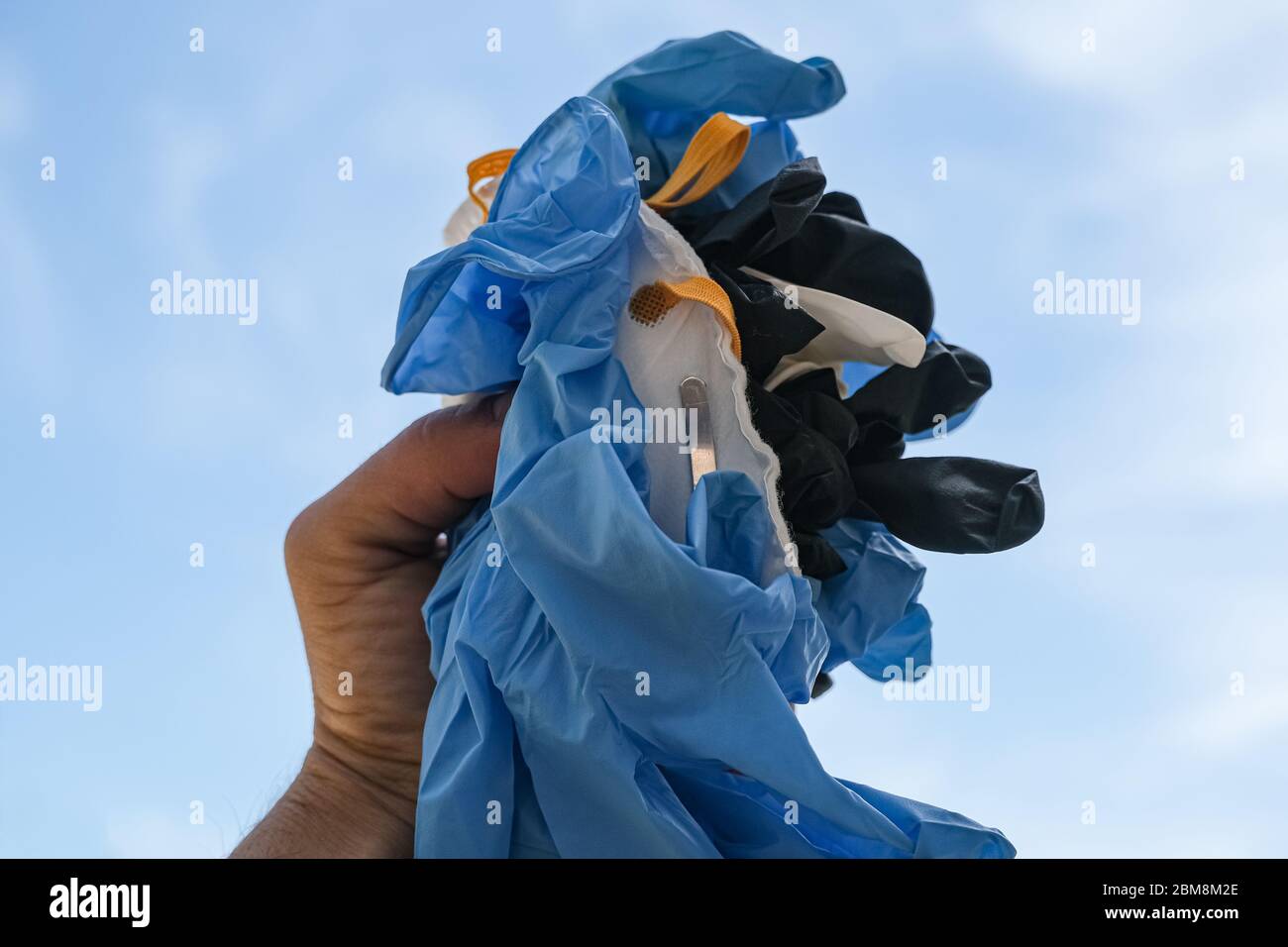Uomo tenere maschera medica e guanti protettivi sporco spazzatura, coronavirus attrezzature Foto Stock