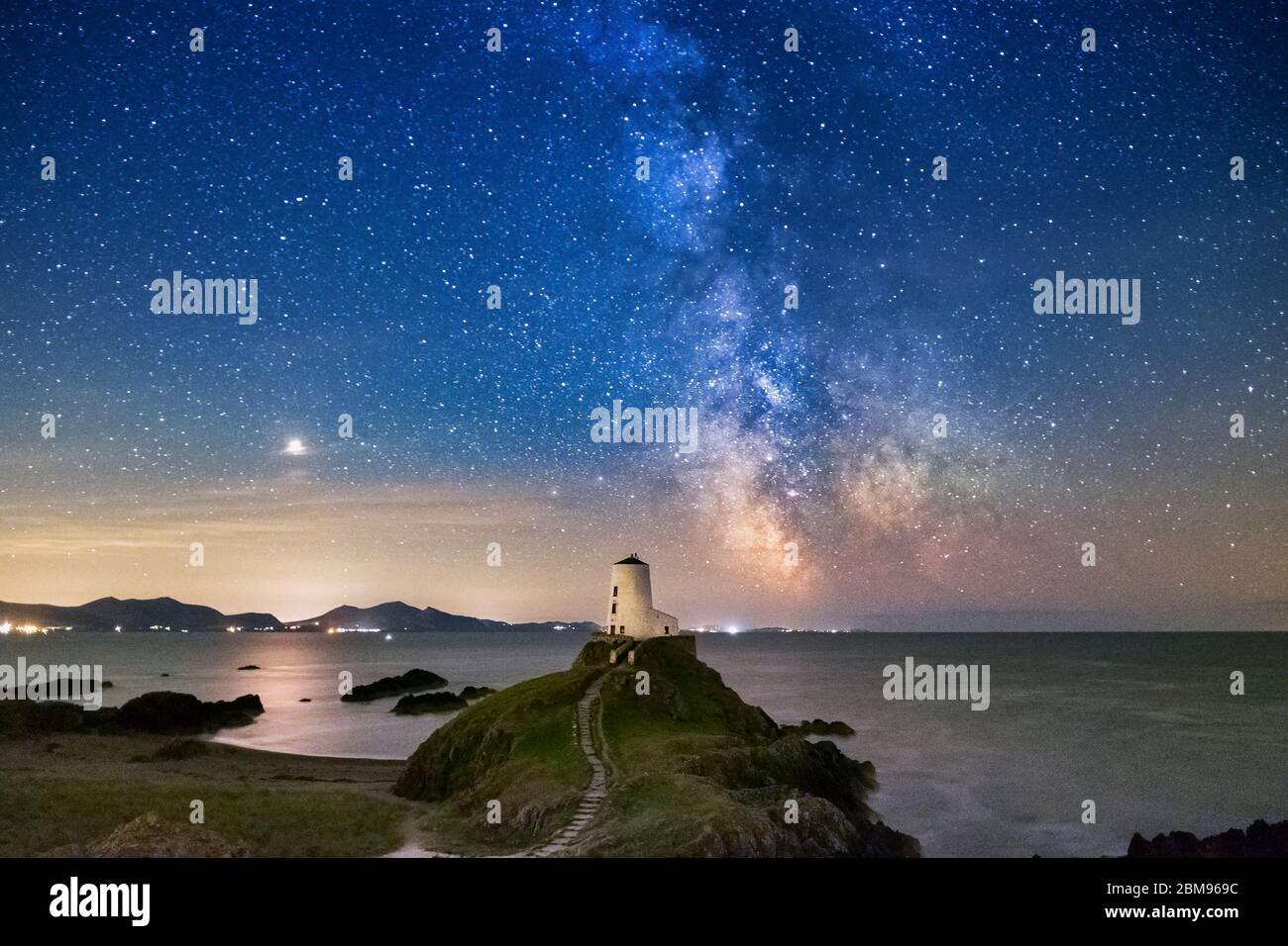 La Via Lattea e cielo notturno sopra Twr Mawr Faro, Llanddwyn Island, Anglesey, Galles del Nord, Regno Unito Foto Stock