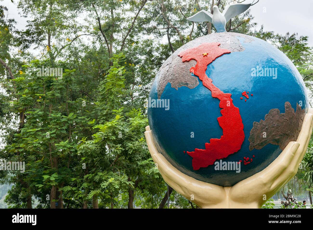 Hanoi Vietnam Ottobre 24 2013; mappa simbolica di rosso brillante del Vietnam tenuto in mano eretta in statua in Hanoi. Foto Stock