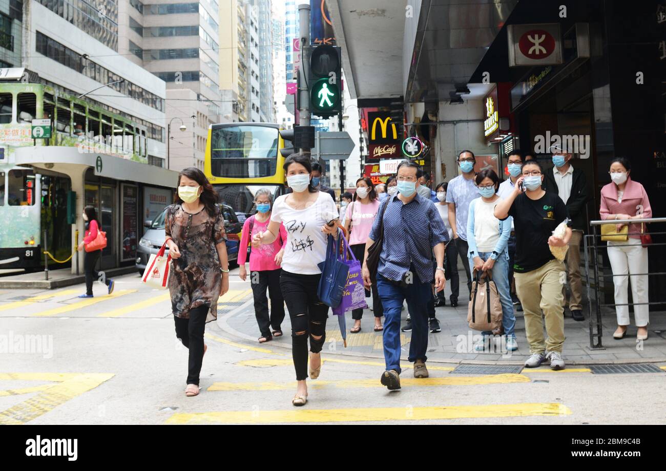 Hongkongers che indossano maschere chirurgiche durante la pandemia di Covid-19. Foto Stock