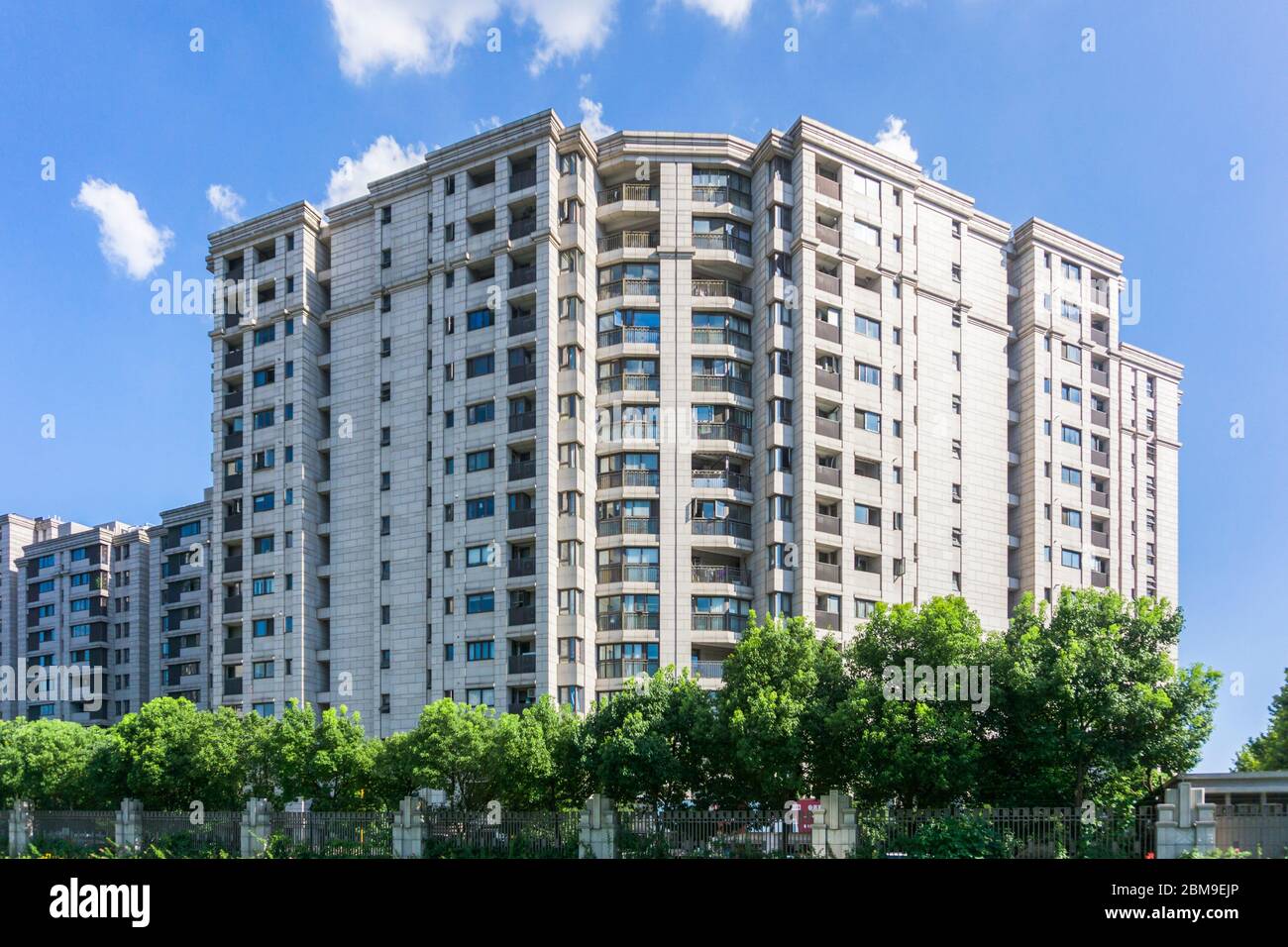 Zona residenziale sotto cielo blu e nuvole bianche Foto Stock