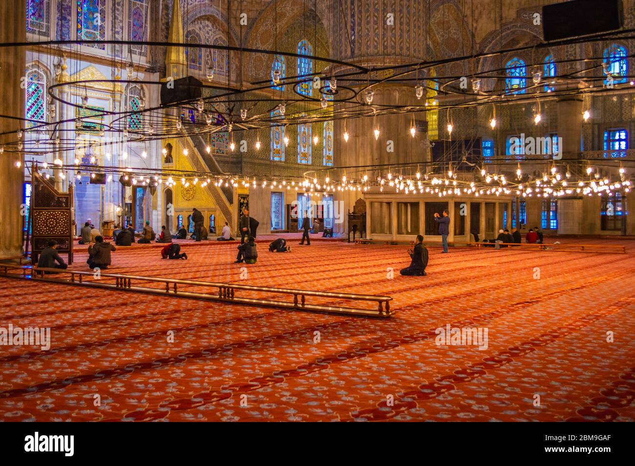 L'interno della Moschea Blu (Moschea del Sultano Ahmed) con molte persone che pregano all'interno. Foto Stock