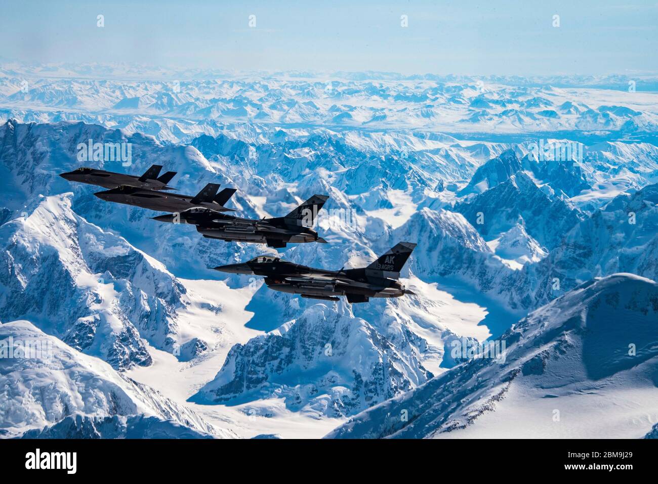 Due F-35A Lightning IIS assegnati al 356° Fighter Squadron e due F-16 Fighting Falcons assegnati al 18° Aggressor Squadron volano sul Denali National Park in Alaska il 5 maggio 2020. Dislocati presso la base aeronautica Eielson, i due combattenti hanno accesso al complesso della gamma congiunta dell'Alaska Pacifico, che è il più grande campo di allenamento del Dipartimento della Difesa che misura più di 77,000 miglia quadrate. (STATI UNITI Foto Air Force di Tech. SGT. Jerilyn Quintanilla) Foto Stock