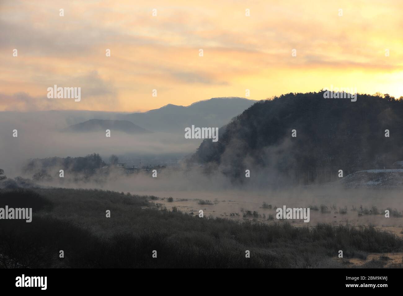 Inverno mattina alba paesaggio di fiumi e montagne nebbie d'acqua. Fiume Sohang, Chuncheon City, Corea Foto Stock