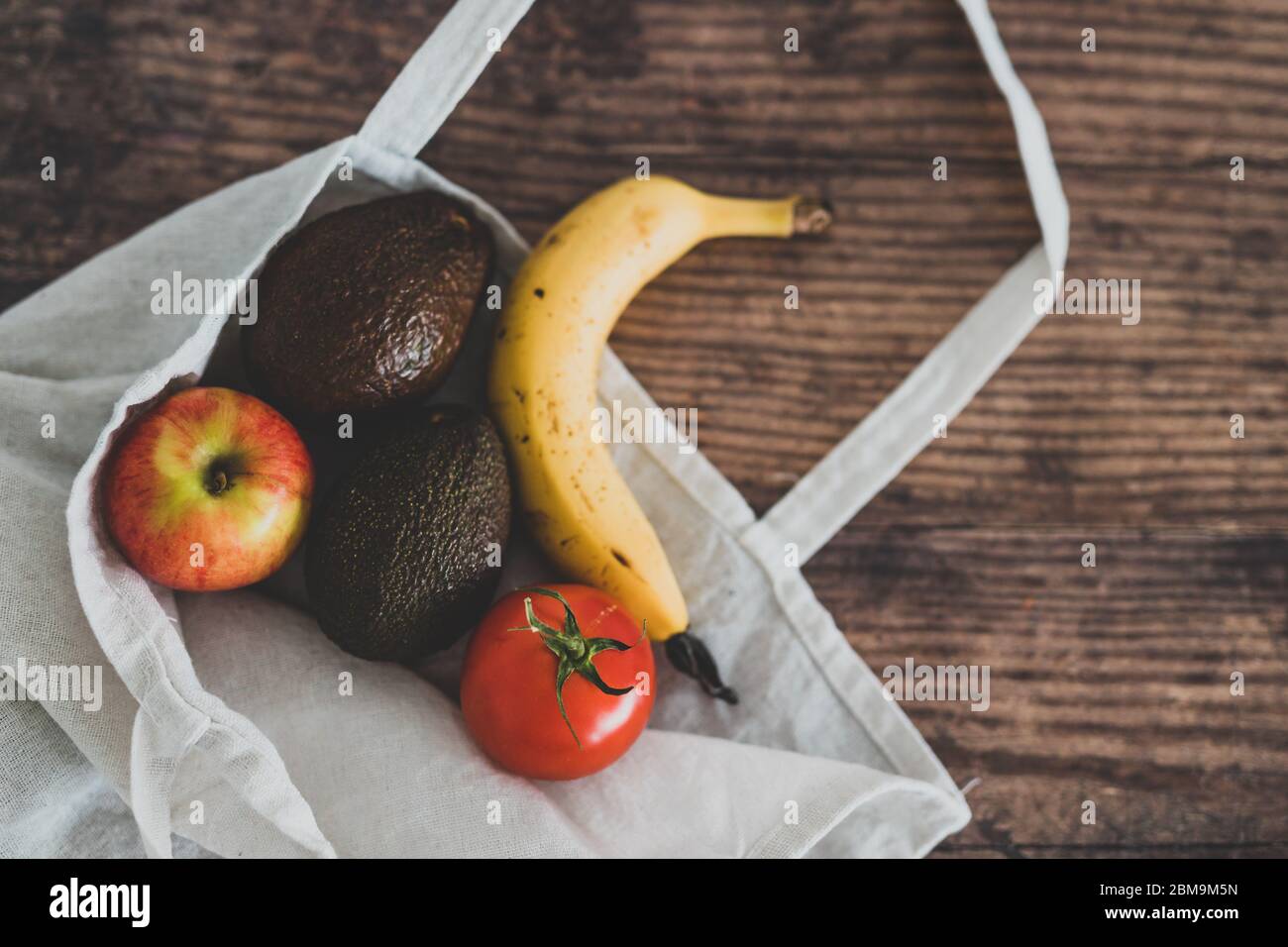concetto di ingredienti alimentari sani a base di piante, borsa con frutta e verdure che ne escono Foto Stock