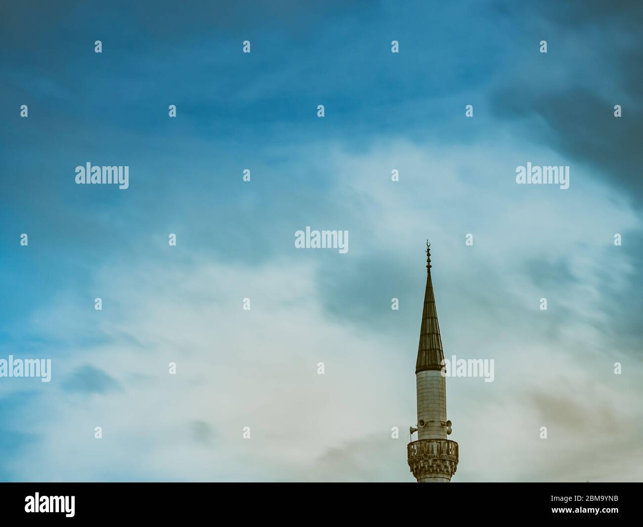 Minareto di una moschea musulmana sullo sfondo del cielo nuvoloso minareto aspirando al cielo. Foto Stock